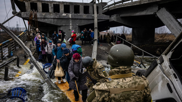 Ucranianos cruzan un puente destruido mientras huyen de la ciudad de Irpin, al noroeste de Kyiv [Kiev], el 7 de marzo de 2022.