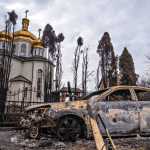 Una iglesia dañada y un auto incendiado en Irpin, Ucrania, causados por un ataque militar ruso el 9 de marzo de 2022.