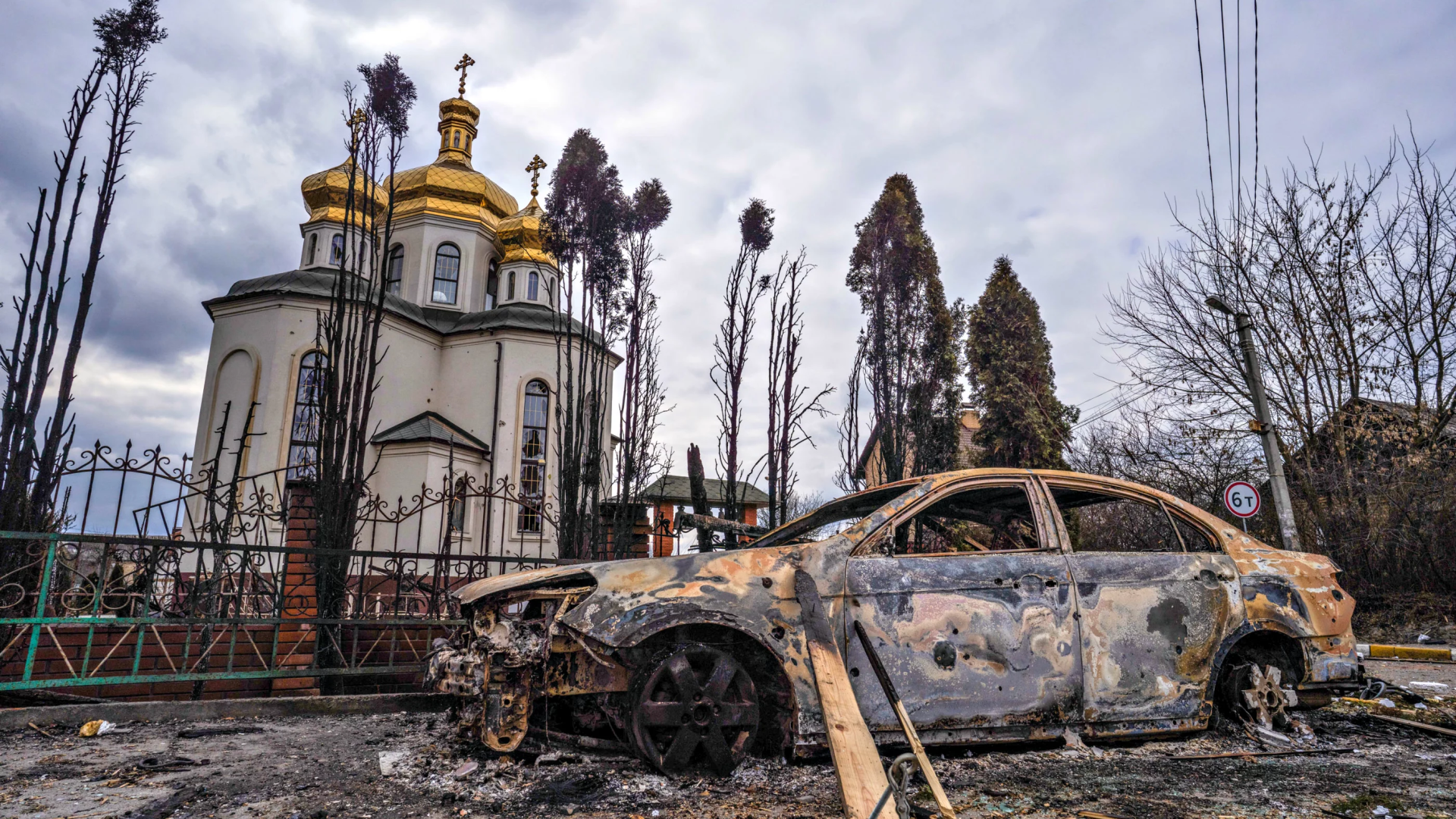 Una iglesia dañada y un auto incendiado en Irpin, Ucrania, causados por un ataque militar ruso el 9 de marzo de 2022.