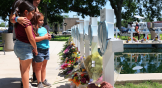 Dolientes visitan el monumento en homenaje a una de las víctimas del tiroteo masivo ocurrido en una escuela primaria, en la plaza principal de Uvalde.