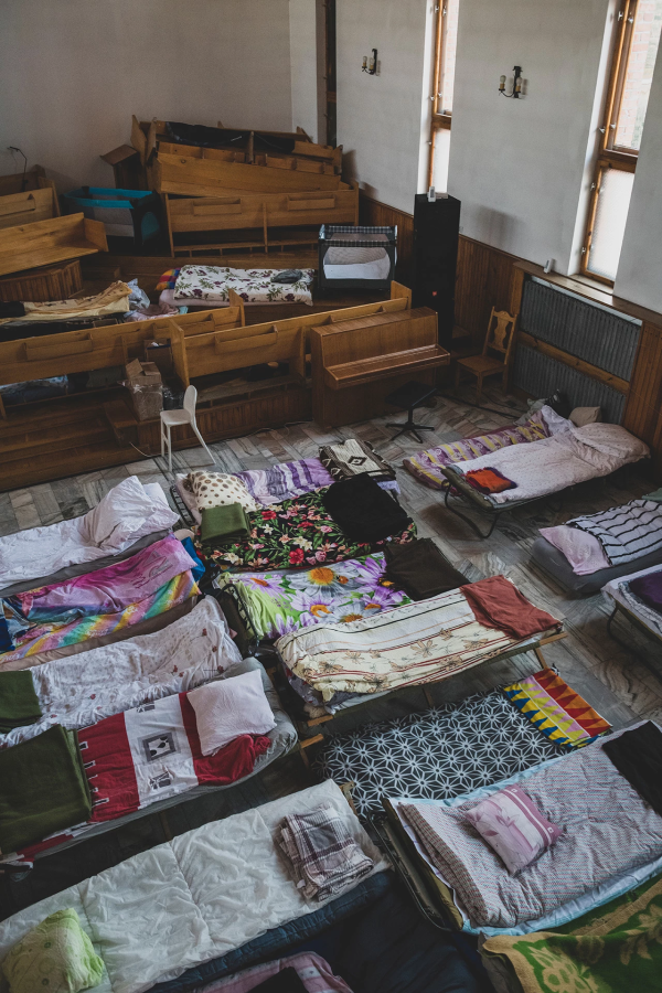 Bancos amontonados en el santuario de la Iglesia Bautista de Chełm para hacer espacio para las camas.