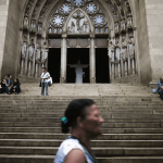 Personas frente a la puerta de una iglesia católica en Brasil.