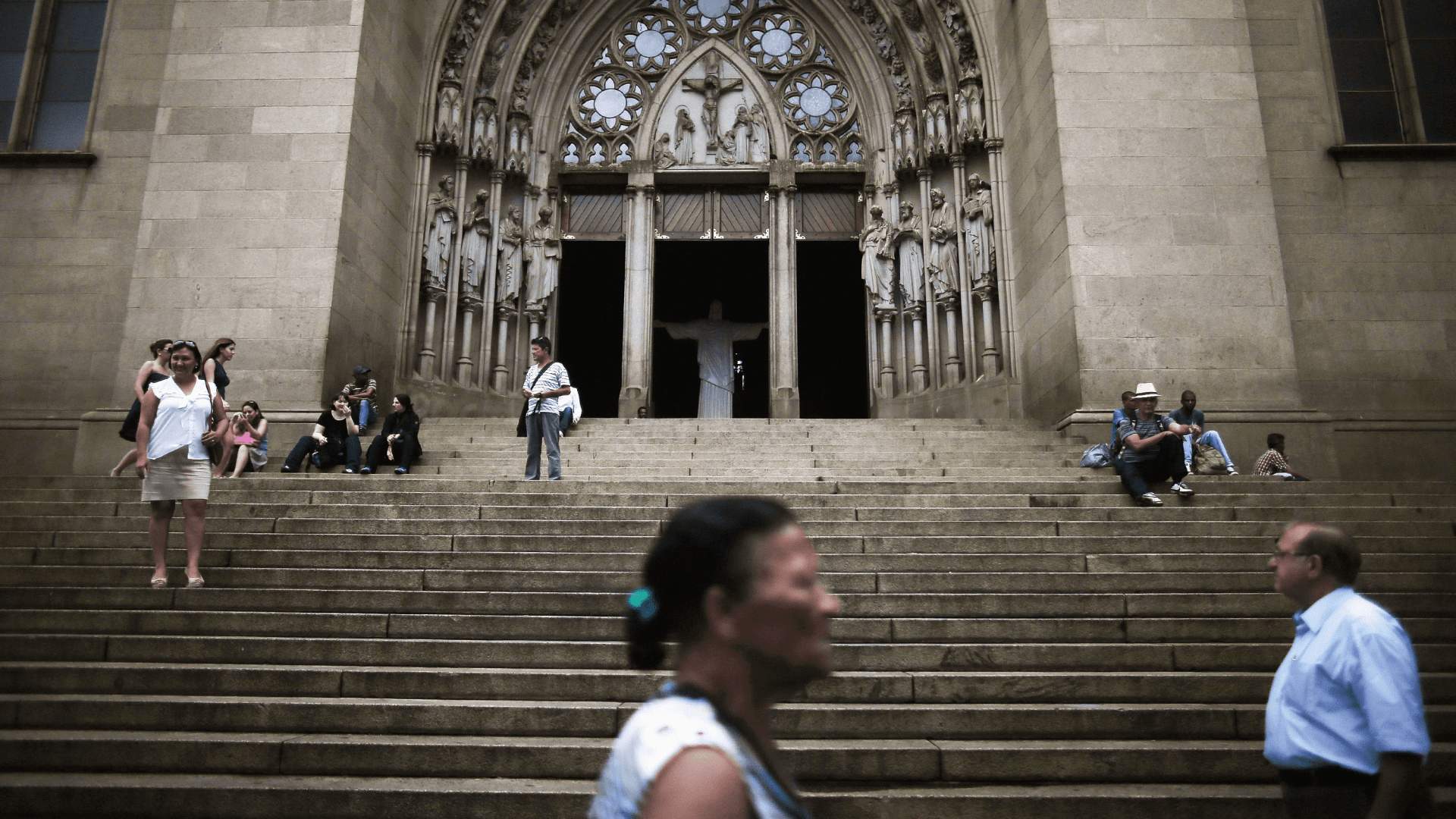 Personas frente a la puerta de una iglesia católica en Brasil.