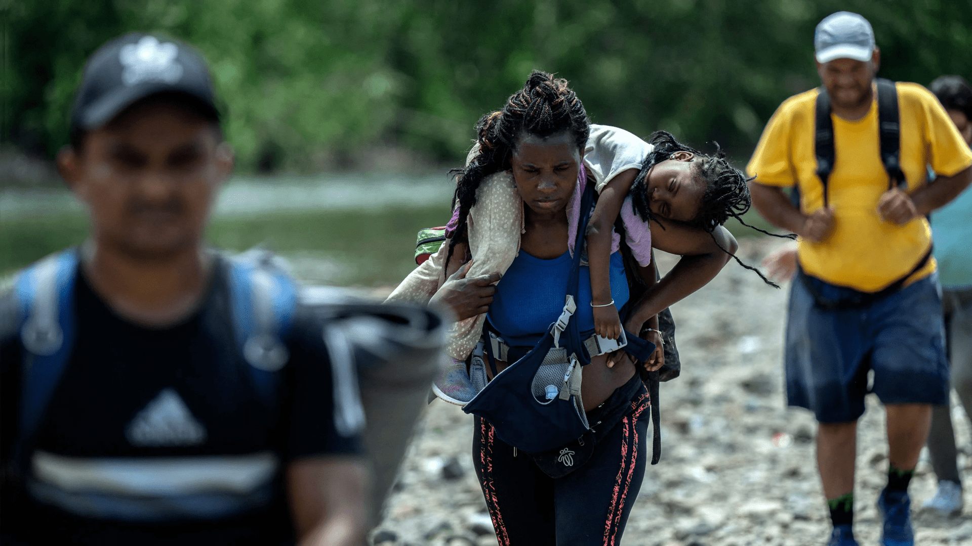 Una mujer migrante lleva a su hija en hombros cerca del primer control fronterizo de la provincia de Darién, en Panamá.