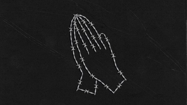 Barbed wire in the shape of praying hands on a black background.