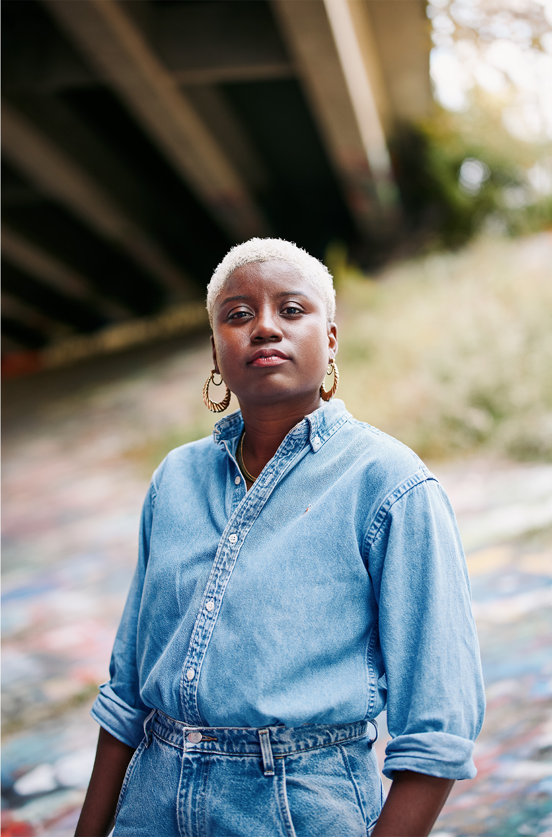 Headshot of Caresse Dionne standing under a freeway overpass