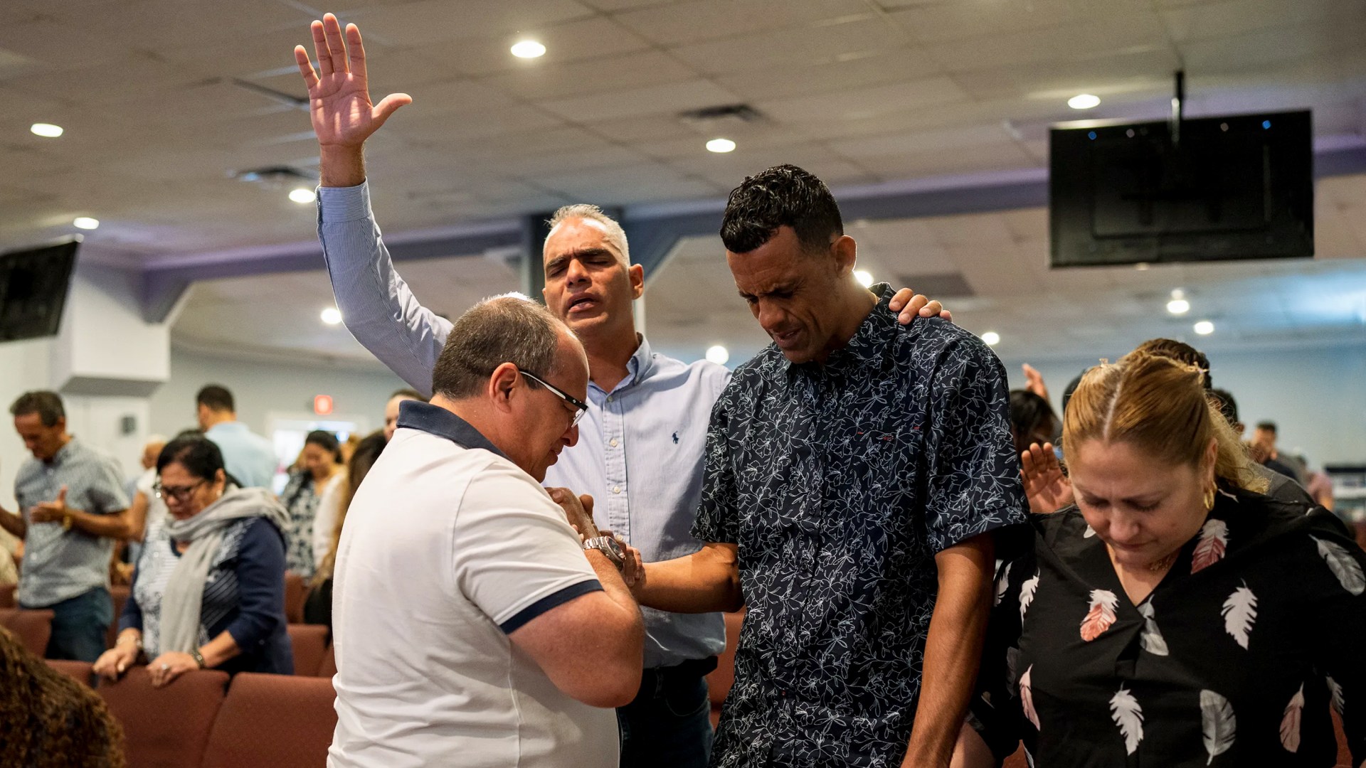 Creyentes oran por inmigrantes indocumentados durante un servicio en la Iglesia Rescate de Miami en 2023.