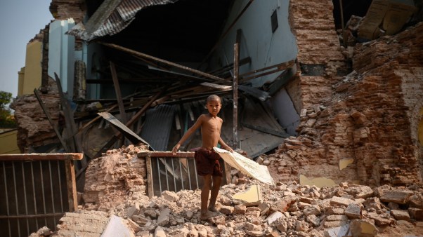 Un joven monje budista observa los escombros del dañado monasterio de Thahtay Kyaung en Mandalay.