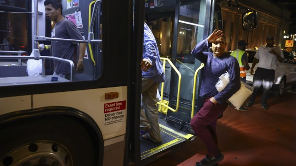 Migrantes en Chicago suben a un autobús con destino a un centro de acogida.