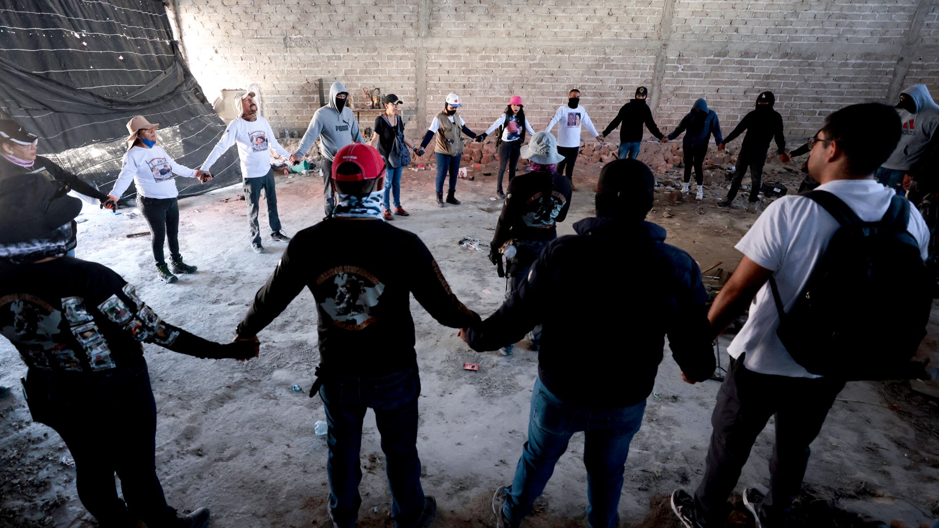 Miembros del grupo Guerreros Buscadores oran en el Rancho Izaguirre, donde localizaron tres crematorios humanos mientras buscaban a sus familiares en México.