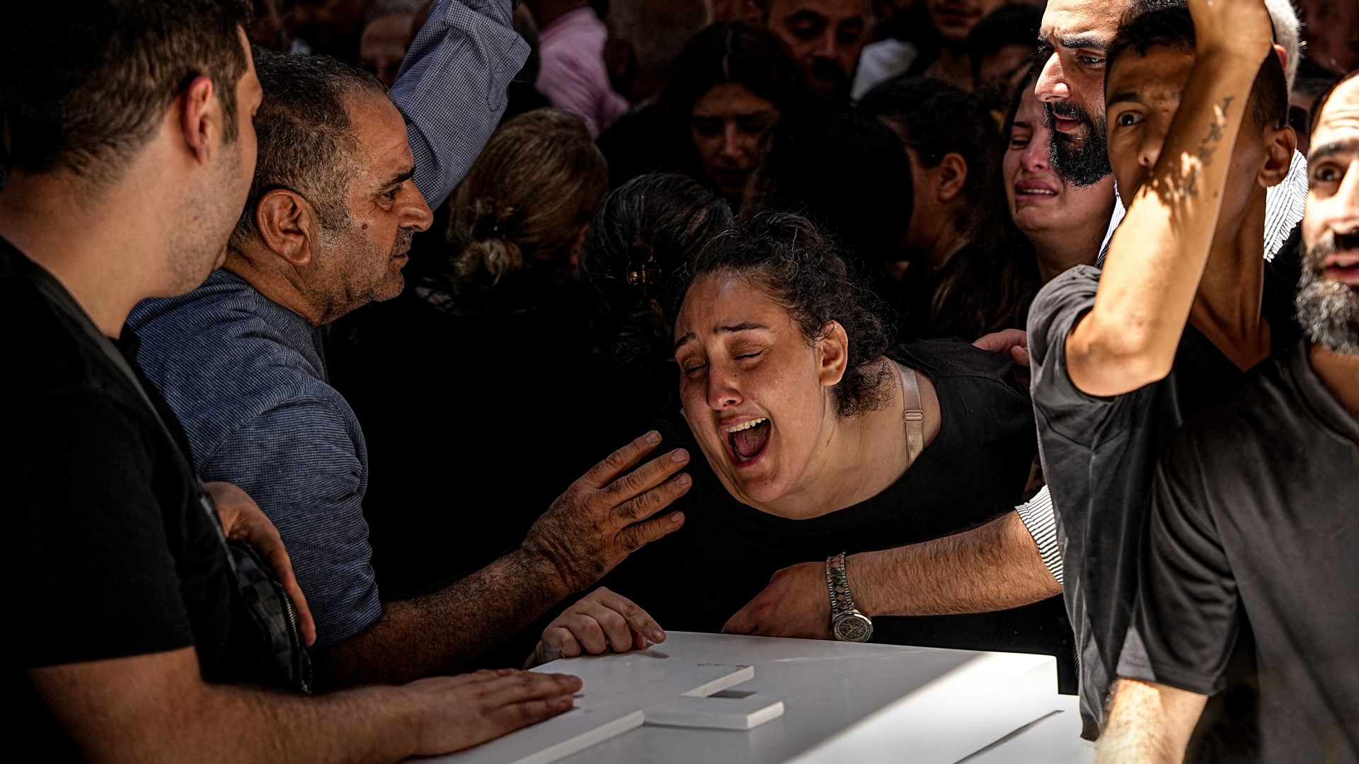 Familiares lloran durante el funeral de las víctimas del atentado contra la iglesia ortodoxa griega de San Elías en Siria.
