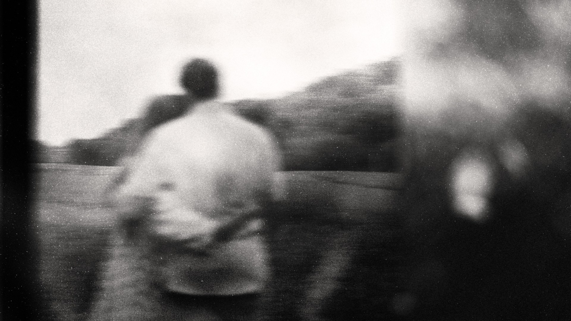 A blurry black and white photo of a couple hugging.
