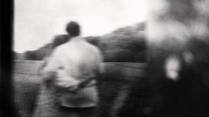 A blurry black and white photo of a couple hugging.