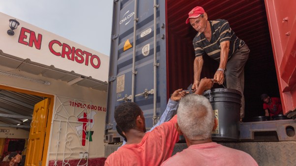 Miembros de la iglesia Hermanos en Cristo Faro de Luz descargando suministros que serán distribuidos a las personas de la iglesia y la comunidad.